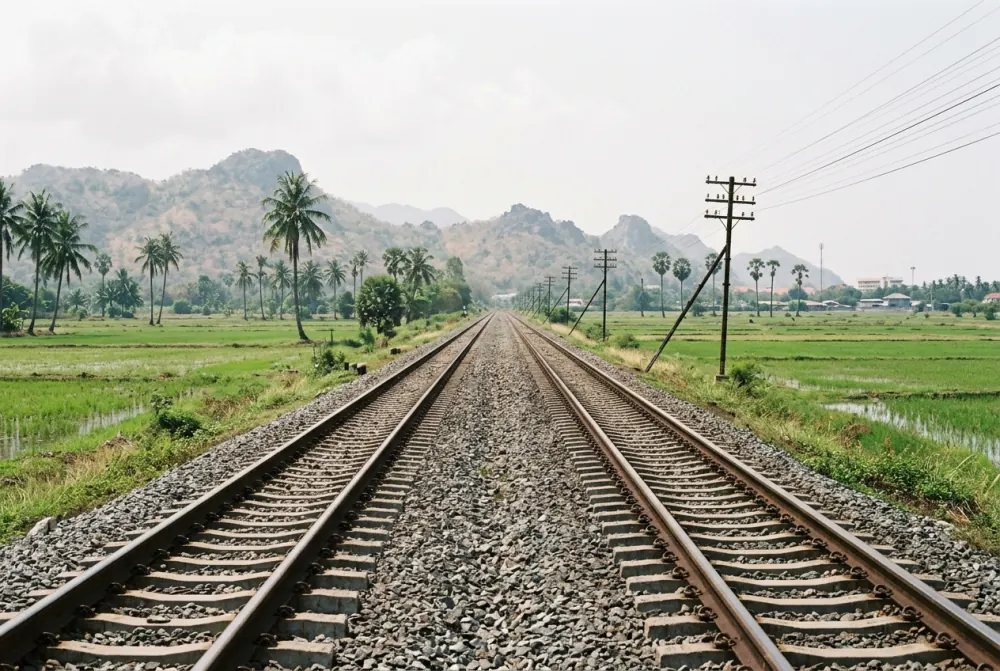 Empty double-track railway running south through flat coastal country