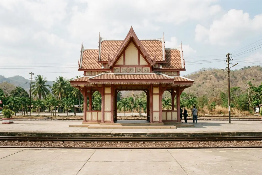 Ornate timber railway pavilion in traditional Thai style on a station platform